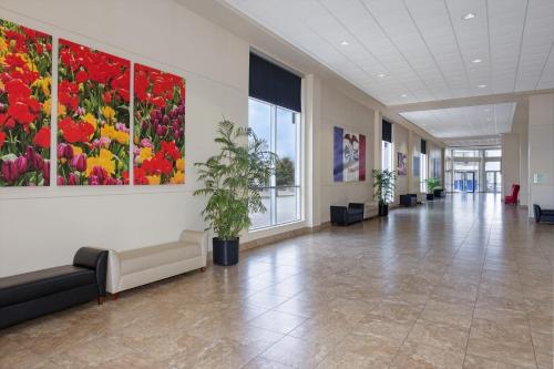 an office lobby with paintings on the wall and a waiting room at Holiday Inn Des Moines-Airport Conf Center by IHG in Des Moines