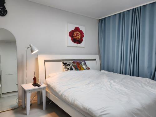 ein Schlafzimmer mit einem weißen Bett und einem Beistelltisch in der Unterkunft Welcome to Jejubi house in Jeju-do