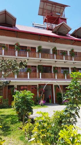 a large building with potted plants on the balconies at Hospedaje Oxa Paraíso in Oxapampa