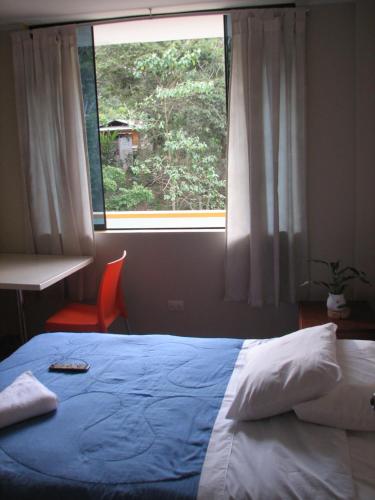 Cama en habitación con ventana grande en Casa Alojamiento La Stancia, en Villa Rica