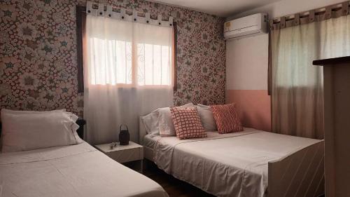 a bedroom with two beds and a window at Casa Nórdica in Taganga