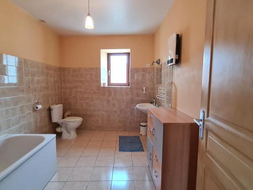 ein Badezimmer mit einer Badewanne, einem WC und einem Waschbecken in der Unterkunft Gîte Méligny-le-Grand, 4 pièces, 6 personnes - FR-1-585-29 