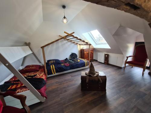 a attic room with two bunk beds and a chair at Gîte enchanteur avec déco sorciers, piscine, proche forêt et chemins de randonnée, idéal pour familles - FR-1-591-383 in Chitray