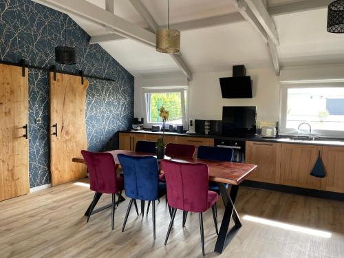 une salle à manger avec une table et des chaises dans l'établissement Chalet cosy à La Flèche avec terrasse et vue rivière - FR-1-410-424, à La Flèche