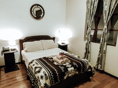 a bedroom with a bed with a doll on it at HOTEL en el CENTRO HISTORICO in Cuenca
