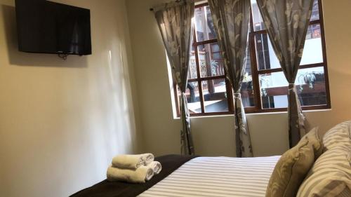 a bedroom with a bed and a television and a window at HOTEL en el CENTRO HISTORICO in Cuenca