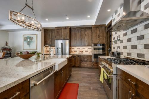 a kitchen with wooden cabinets and stainless steel appliances at Allure at Schaffer's Mill by Tahoe Getaways - 4BR Pet-Friendly Home w Private Hot Tub & Air Conditioning! in Truckee