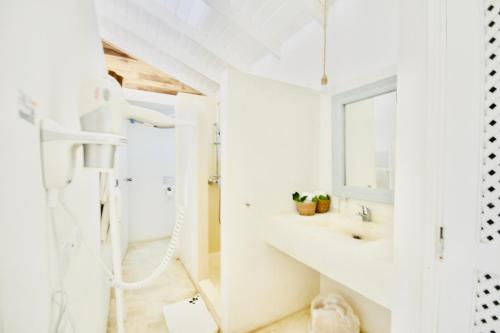 La salle de bains blanche est pourvue d'une douche et d'un lavabo. dans l'établissement non disponible, à Las Terrenas