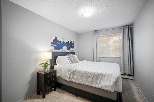 a bedroom with a bed and a window at CHIC 2BR Near Keyano College Free Parking in Fort McMurray