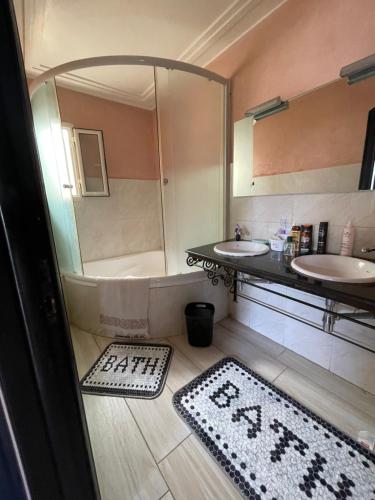 a bathroom with two sinks and a tub and two rugs at Appartement vue sur mer in Agadir