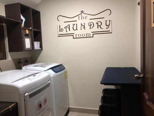 a kitchen with a laundry room with a sign on the wall at HOTEL en el CENTRO HISTORICO in Cuenca