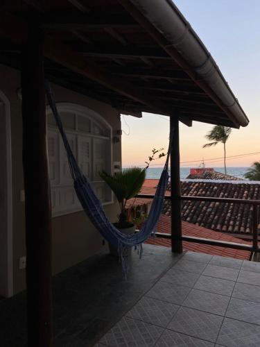 a hammock on a house with a view of the ocean at Pousada Nativo in Morro de São Paulo