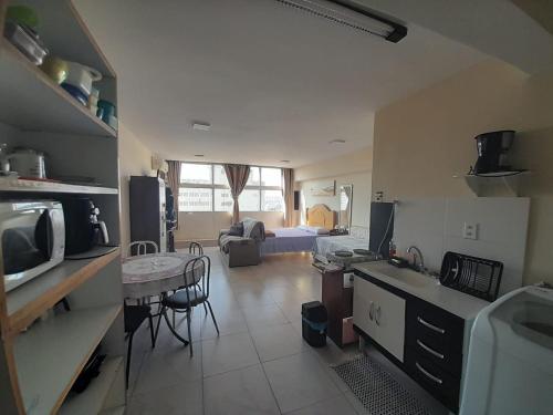 cocina y sala de estar con fregadero y mesa en Studio Aconchegante - Centro São Paulo 300Mb, en São Paulo