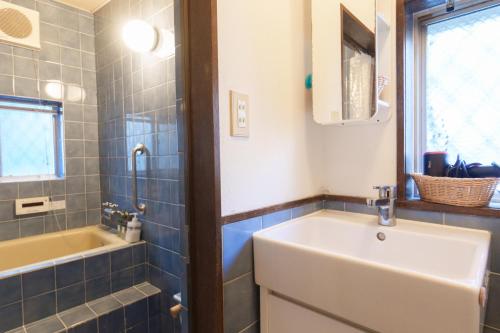 a bathroom with a sink and a bath tub at hostel Ini kobe l Self Cozy Stay in Kobe