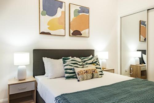 una camera con un letto con due comodini e due lampade di Brand New Modern 3br2ba Townhouse Glen Waverley a Glen Waverley