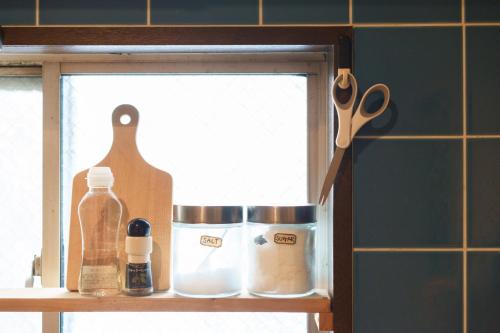 a shelf with a pair of scissors and other kitchen items at hostel Ini kobe l Self Cozy Stay in Kobe