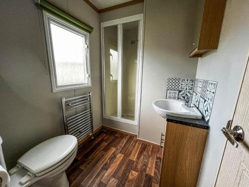 a bathroom with a toilet and a sink at Superb 6 Berth Caravan With Decking At Seawick Holiday Park, Essex Ref 27009mv in Clacton-on-Sea