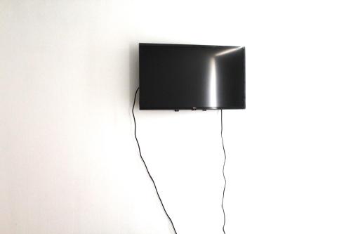 a flat screen tv hanging on a wall at Grandioso departamento a cuadras de Parque O'higgins in Santiago