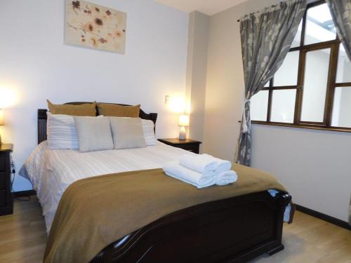 a bedroom with a bed with towels on it at HOTEL en el CENTRO HISTORICO in Cuenca