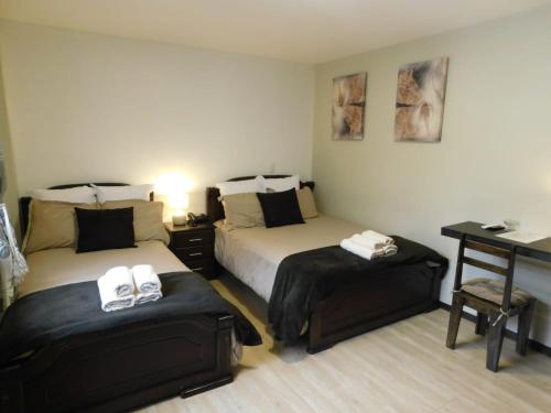 Habitación de hotel con 2 camas y escritorio en HOTEL en el CENTRO HISTORICO, en Cuenca