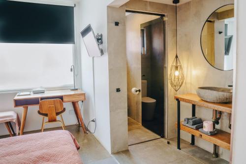 a bathroom with a sink and a desk and a mirror at The Pink Hotel Coolangatta in Gold Coast