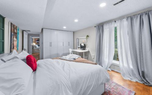 a bedroom with a white bed and a window at Spacious bedroom with garden view, fridge, workspace in Toronto