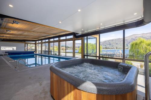 a large bath tub in a room with a pool at Marina Views - Luxury Apartment in Wanaka