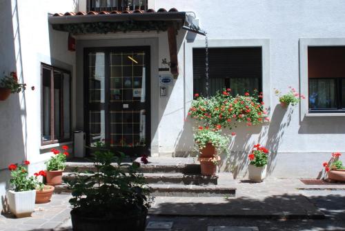 a house with potted plants and a door with flowers at Albergo Alla Valle di Banne in Trieste