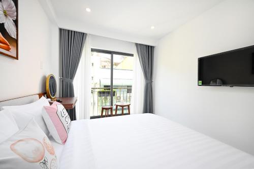 a hotel room with a bed and a tv at Saigon Hotel & Apartment in Ho Chi Minh City