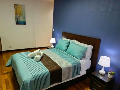 a bedroom with a bed with blue walls at Hermoso Departamento En La Mejor Zona De Cochabamba in Cochabamba