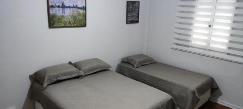 a bedroom with two twin beds and a window at Big apartment close to Allianz Park in Sao Paulo