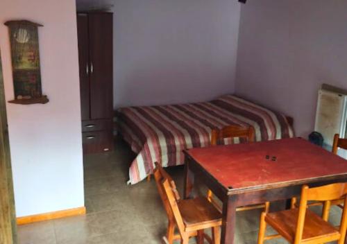 Habitación pequeña con mesa y cama en La Casita del Oso en San Carlos de Bariloche