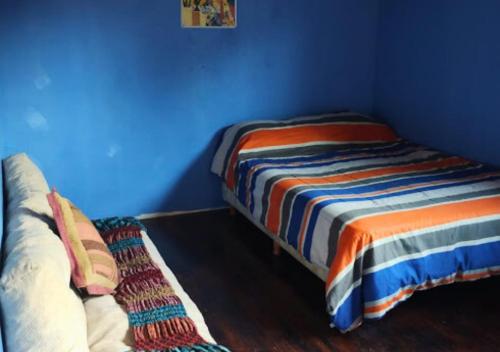 1 dormitorio con cama y pared azul en La Casita del Oso en San Carlos de Bariloche