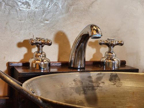 a bathroom sink with two faucets on top of it at Cabañas Alechen in El Calafate