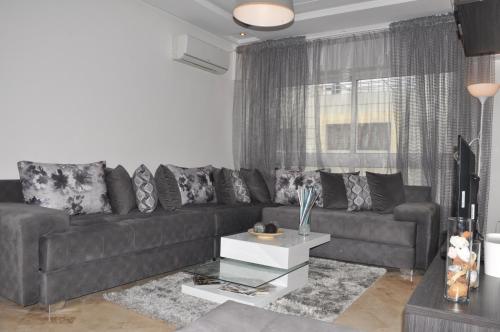 a living room with a couch and a table at Val Fleuri Apartment with 2 Balconies, Casablanca in Casablanca