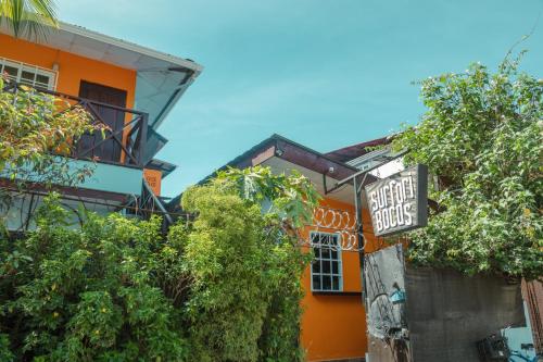 an orange building with a sign that reads guest house at Surfari Bocas in Bocas del Toro