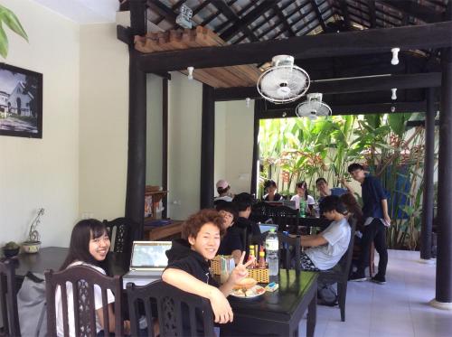 eine Gruppe von Personen, die in einem Restaurant an Tischen sitzen in der Unterkunft Starfruit Villa in Hoi An