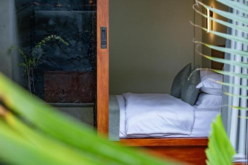 a small bedroom with a bed and a mirror at Sunny Breeze View in Hangnaameedhoo