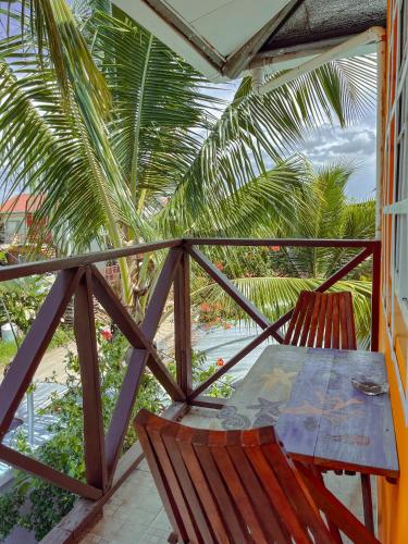 a table and chairs on a balcony with palm trees at Surfari Bocas in Bocas del Toro