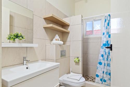 a bathroom with a toilet and a sink and a window at Beautiful and Spacious Mediterranean Style Villa on Palm Beach in Palm-Eagle Beach