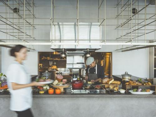 a man in a kitchen preparing food in a kitchen at HOTEL ANTEROOM NAHA in Naha