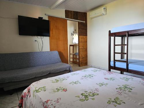 a bedroom with a bed and a flat screen tv at Tranquilidade e vista privilegiada in Ilhabela