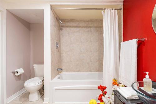 ein Badezimmer mit einer weißen Badewanne und einem WC in der Unterkunft KD Bachelor Suite - Lower Level in Barrie