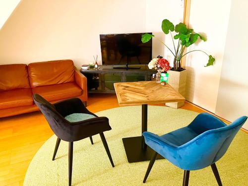 een woonkamer met 2 stoelen en een bank bij ゲストハウス西金沢Smile&smile in Kanazawa