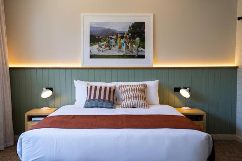 a bedroom with a large bed with two lamps at The Clovercrest Hotel Motel in Modbury