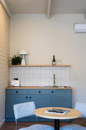 a kitchen with a table and two chairs and a sink at The Clovercrest Hotel Motel in Modbury