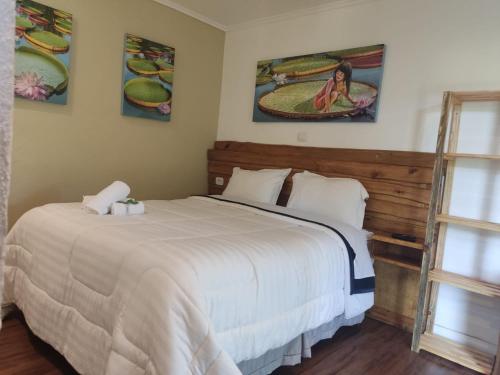 a bedroom with a large white bed and a window at Pousada Pinhalense in Santo Antônio do Pinhal