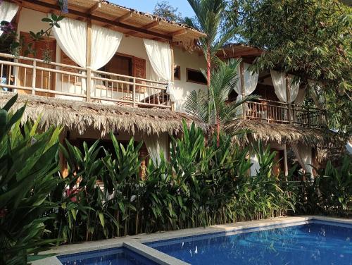 a resort with a swimming pool in front of a building at Black Bamboo B&B in Puerto Viejo