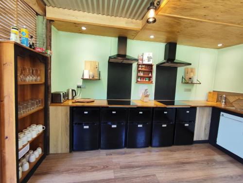 a kitchen with black counters and wooden cabinets at Glamping at Zeehan Bush Camp in Zeehan
