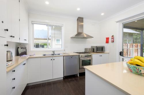 a kitchen with white cabinets and a stove top oven at Serenity Halls Gap 2 Absolute NP Frontage in Halls Gap